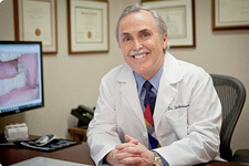 Dr. Briscoe smiling at desk in white coat