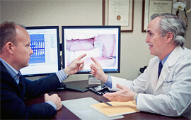 Dr. Charles Briscoe talking with patient while looking at photos of patients teeth