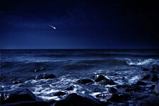 Ocean waves at night with shooting star in the sky