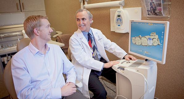 Dr. Briscoe looking at images of patients teeth on CEREC computer system