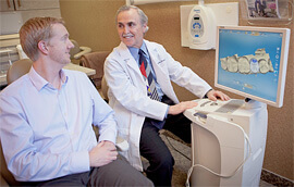 Dr. Briscoe talking with patient while looking at computer generated images of teeth