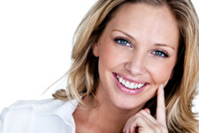 Blonde woman smiling with hand on face