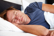 Man sleeping in bed in blue shirt
